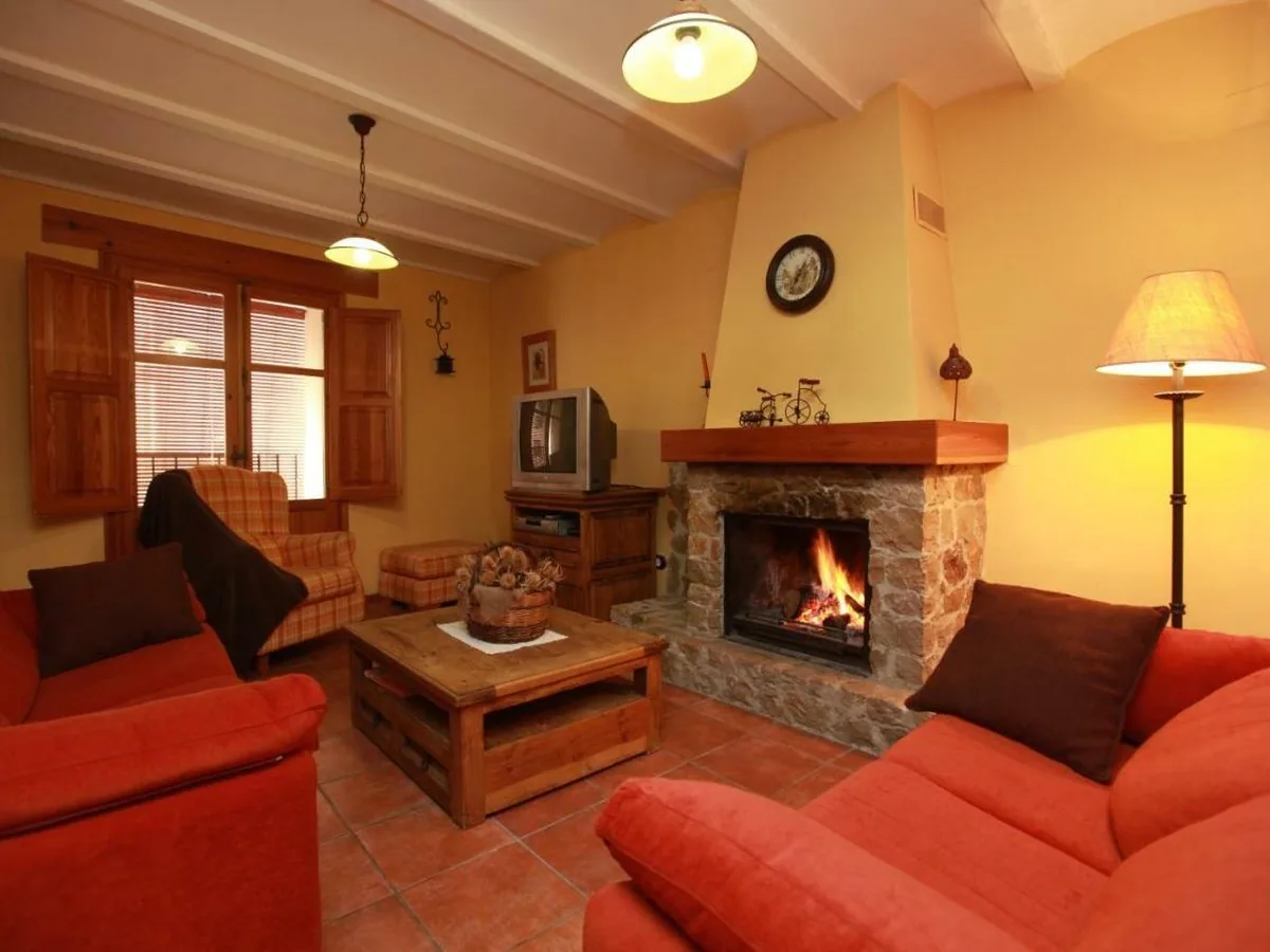 Salón con chimenea encendida de la casa rural de Cabanes