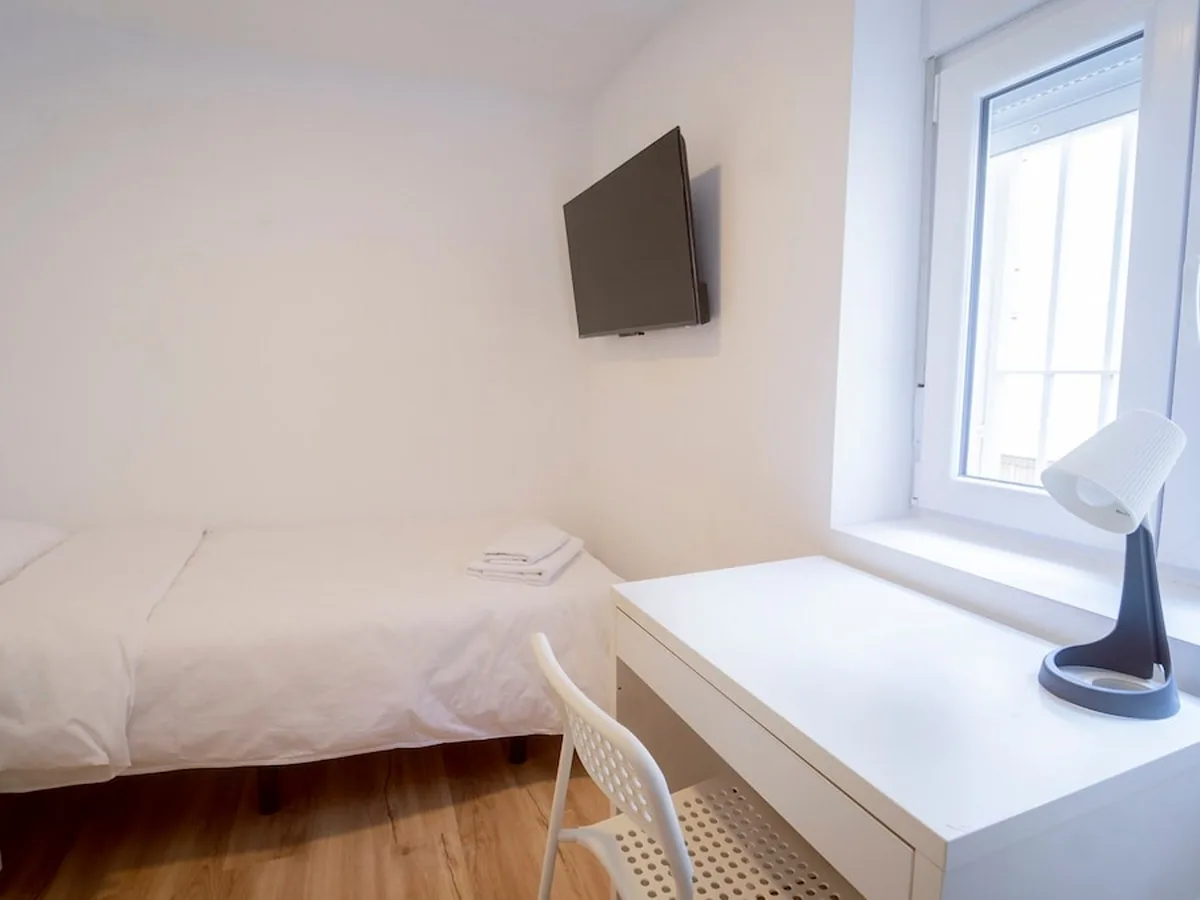 Habitación luminosa con escritorio y televisión en un apartamento de Armilla, Granada
